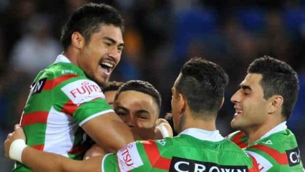 Dylan Walker is swamped by South Sydney teammates after scoring against Gold Coast on Saturday night.