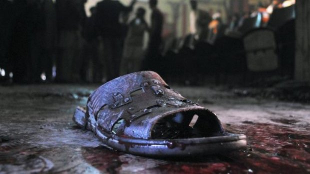 A blood-stained shoe of a victim lies on the ground at the site of a grenade attack on a crowded movie theatre that killed and wounded many people in Peshawar, Pakistan.