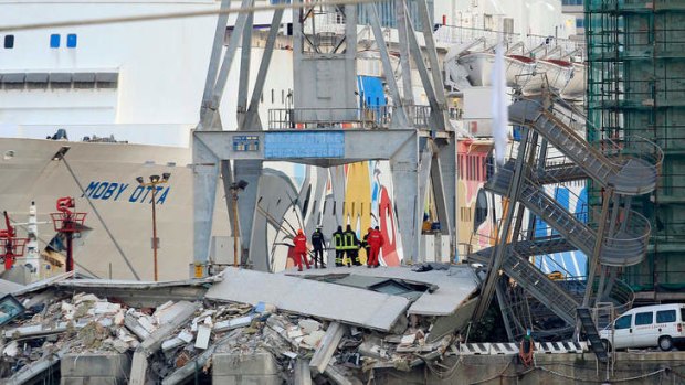 Collision: Rescuers search the wreckage of a harbour control tower in Genoa, Italy, after a container ship crashed into it, killing up to eight people.