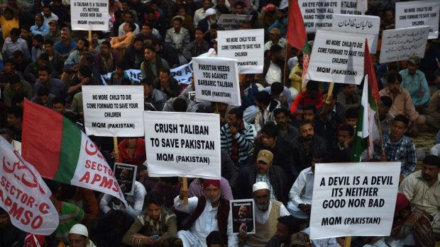 Activists  of Muttahida Qaumi Movement (MQM) party hold anti-Taliban placards in a protest rally in Karachi on Friday.