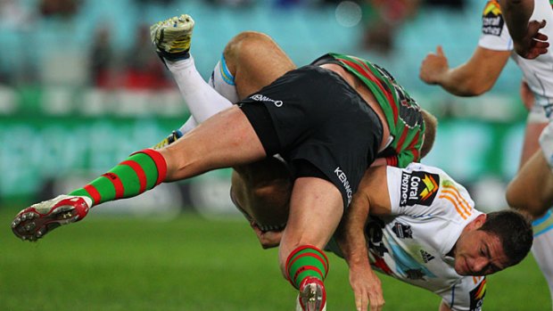 The Titans' Mark Minichiello is tackled by Souths' Michael Crocker.