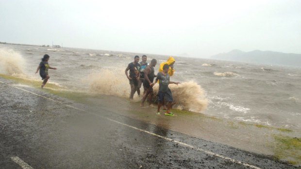 People are splashed by a wave whipped up by cyclone Winston in Labasa, Fiji.