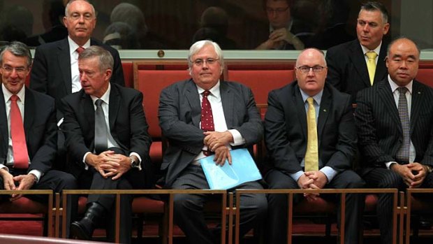 Palmer United Party leader Clive Palmer, centre, observes PUP Senators being sworn into the Senate.