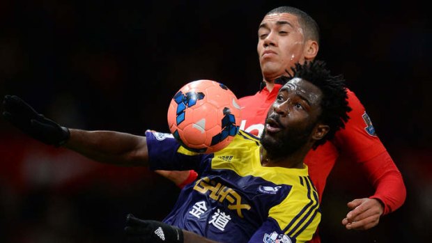 Swansea City's Ivorian striker Wilfried Bony (left) controls the ball under pressure from Manchester United's English defender Chris Smalling.