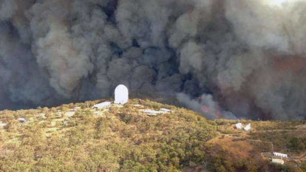 Aerial picture shows smoke billowing from an out-of-control fire raging towards the Siding Spring Observatory (centre), a remote global research facility in the Warrumbungle ranges about 500km north-west of Sydney.