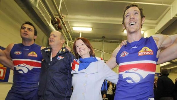 Prime Minister Julia Gillard joins Brian Lake (left),  Rodney Eade and Robert Murphy (right) in singing the Bulldogs' song yesterday.