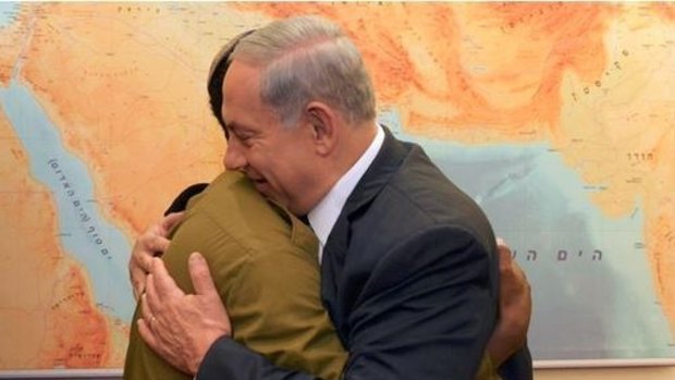 Israeli Prime Minister Benjamin Netanyahu embraces Damas Pakada, the soldier seen in the video footage on Monday.