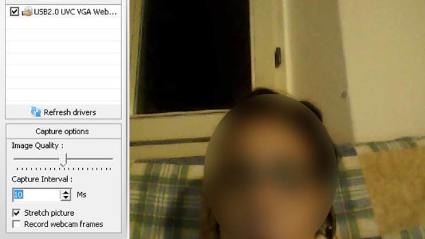 An image uploaded to a hacking forum showing a woman looking at her computer as seen through her webcam.