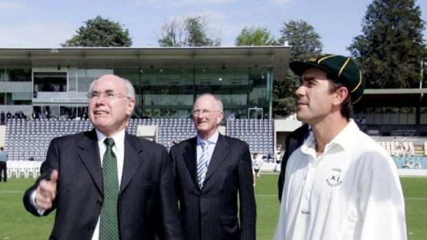 Australian Cricketer Justin Langer, right, watches Australian Prime Minister John Howard toss the coin before the PM's XI match at Manuka Oval  in 2005.