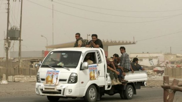 Shiite fighters patrol the streets of Samarra during a sand storm. 