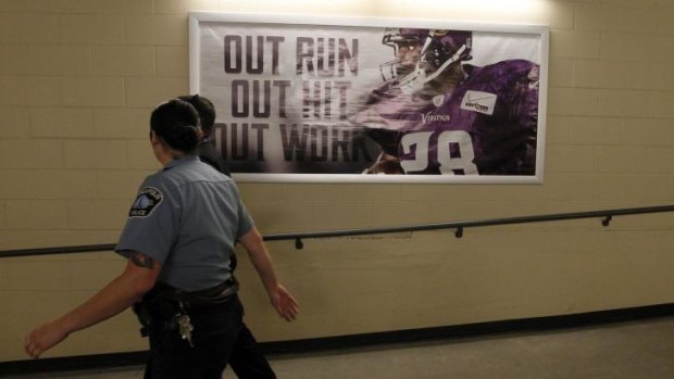 A member of the Minneapolis police department walks past a photo of Minnesota Vikings running back Adrian Peterson.