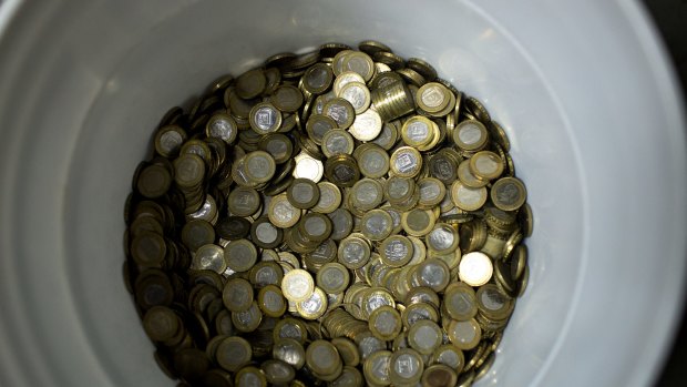 A bucket of bolivar coins in a market in Caracas.