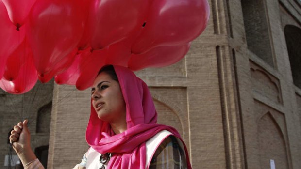 An Afghan woman holds a portion of some 10,000 pink balloons handed out by artists and activists in Kabul, Afghanistan, Saturday, May, 25, 2013. The project brought smiles to surprised Afghans on the street a day after a major Taliban siege on an international compound.