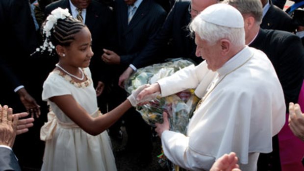 Sticking to Catholic doctrine...Pope Benedict XVI is greeted by a girl on his arrival at Yaounde on a six-day visit to Africa.
