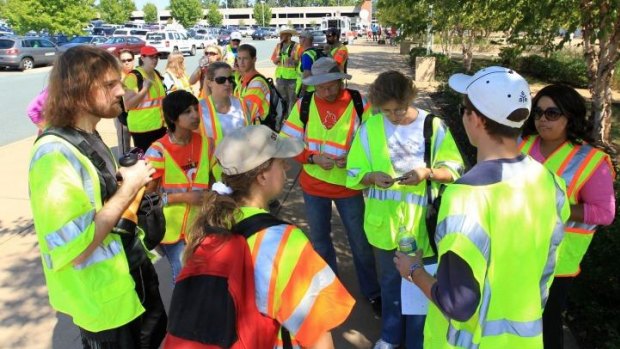 Volunteers talk with their team leader outside the John Paul Jones Arena before participating in a massive search effort by the community for missing University of Virginia student Hannah Graham.
