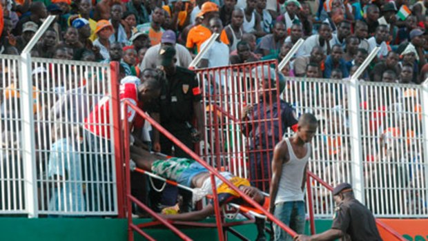 An injured spectator is carried from the stadium after a crush at a World Cup qualifying match between Ivory Coast and Malawi in Abijdjan.