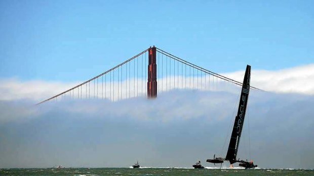 Oracle Team USA warms up near the Golden Gate Bridge before race 14.