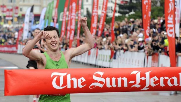 Winners are grinners ... Victoria's Liam Adams takes the men's section of the City2Surf yesterday.