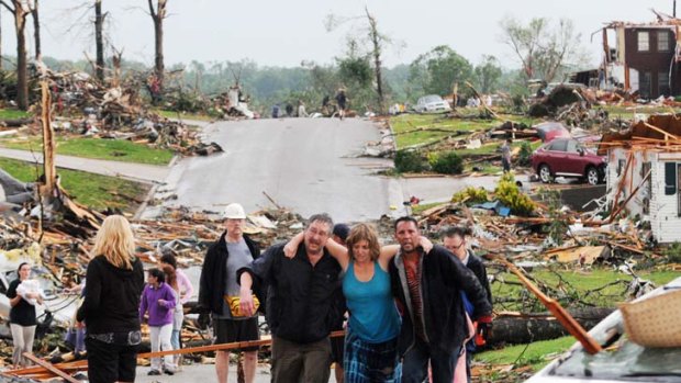 Residents of Joplin, Missouri, help a woman who survived in her basement after a tornado hit the city on Sunday. Photo: AP