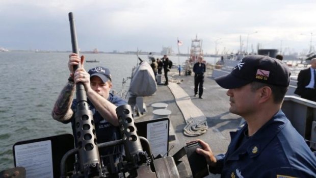 Crew members mount a weapon on the deck of USS destroyer Donald Cook in the Black Sea port of Constanta on April 14, 2014.