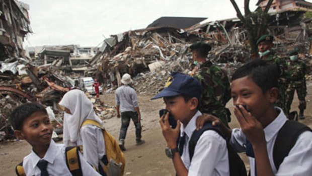 Lessons in store ... pupils walk past the rubble of hotels and shops in Padang as schools opened for the first time since lase week’s earthquake.