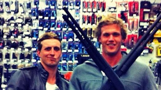 The offending image ... Nick D'Arcy and Kenrick Monk pose in a gun shop in California.