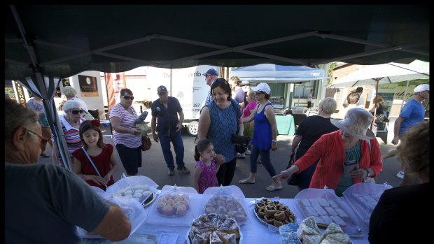 Locals and visitors at the Frangipani Gluten Free stall at Talbot local market . The stall is run by Fran, who has been coming to the market for 8 years.
