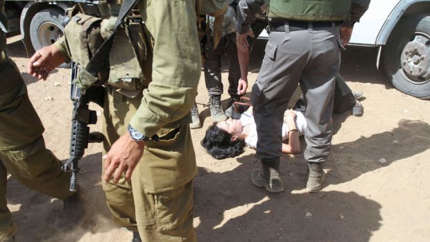 Marion Fesneau-Castaing lies on the ground after she was reportedly dragged out of an aid truck by Israeli soldiers.