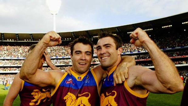 Chris Scott (L) and Brad Scott celebrate their 2002 Brisbane Lions premiership win.