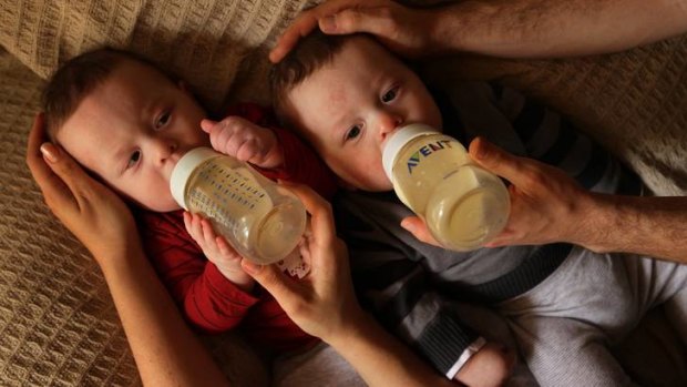 Seven-month-old twin James (left) and Leon are fed milk by their parents at their home in Sydney.