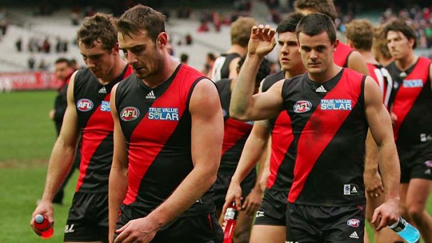 Beaten and bowed: Essendon players leave the field after being thrashed by Carlton in round 21.