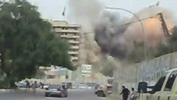 In this image from an amateur video a man runs as one of two huge car bombs explode in central Baghdad.
