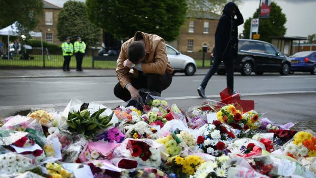 Floral tribute: a man at the scene of the killing.