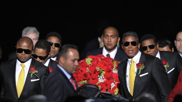 The Jackson Brothers accompany the casket into the memorial service.