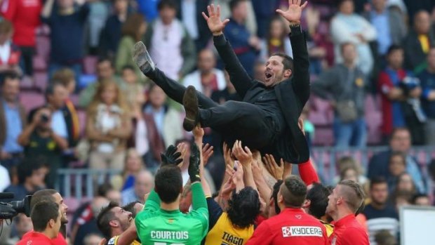 Coach Diego Simeone and the Ateletico players celebrate post-match.
