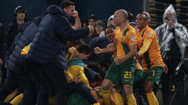 Party time: Socceroos players celebrate Josh Kennedy's goal.