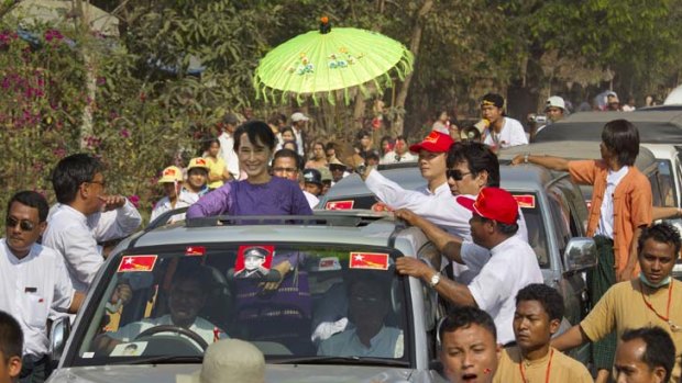 Wild welcome &#8230; Aung San Suu Kyi stands in her car so crowds can see her as she campaigns for the first time in Kaw Hmu, in the southern constituency she hopes to represent.