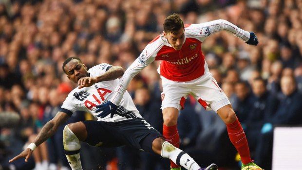 Mesut Ozil and Danny Rose compete for the ball.