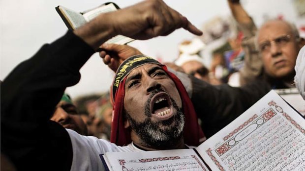New chapter ... a supporter of Mohammed Mursi and the Muslim Brotherhood points to a copy of the Koran during a demonstration in Nasr City, Cairo.