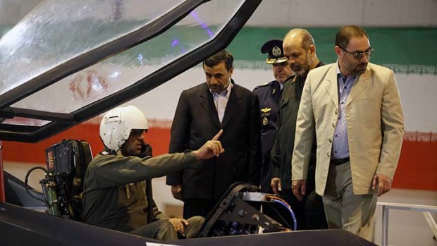 Stealthy or silly? ... Iranian President Mahmoud Ahmadinejad, centre, talks with the pilot of the Qaher 313.