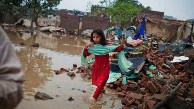 A girl runs through the courtyard of her flood affected home in Nowshera, Pakistan.