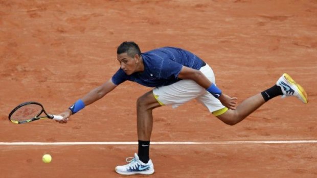 Nick Kyrgios stretches for a forehand return against Milos Raonic.