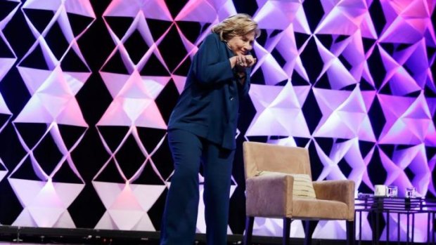 Hillary Clinton ducks after a woman threw an object towards her at a conference in Las Vegas in April.