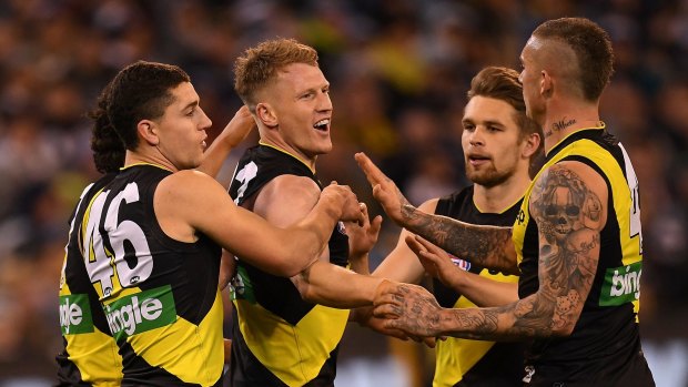 Richmond players celebrate with Josh Caddy (centre) after he kicks a goal in the qualifying final win over Geelong on Friday.