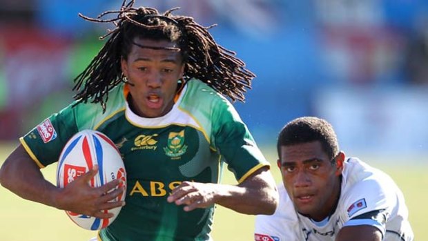 Cecil Afrika of South Africa runs clear against Nikola Matawaiu of Fiji in the Cup final.