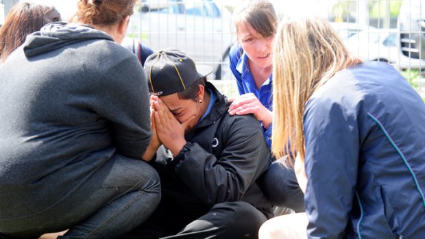 A grief-stricken friend of one of the victims is comforted at the scene.