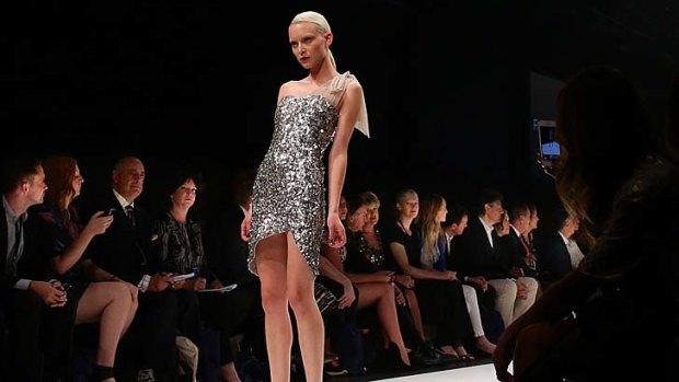Fairfax reporter Natasha Hughes [to left of model] at the opening show at the Melbourne Fashion Festival.