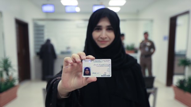 A Saudi women displays her licence at the General Department of Traffic in the capital, Riyadh.