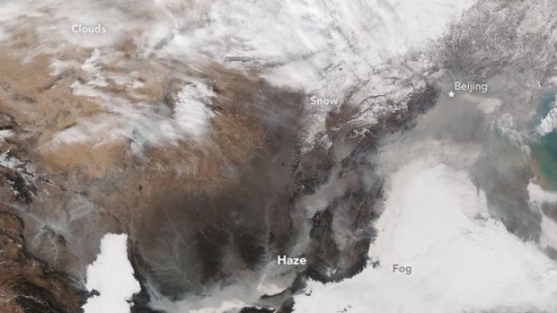 A NASA satellite photo shows smog over Beijing on November 30, 2015. The brightest areas are clouds or fog, tinged with yellow or grey because of air pollution. 