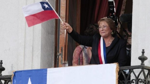 Chile's new President Michelle Bachelet waves a Chilean flag from a balcony at La Moneda presidential palace in Santiago, Chile. 